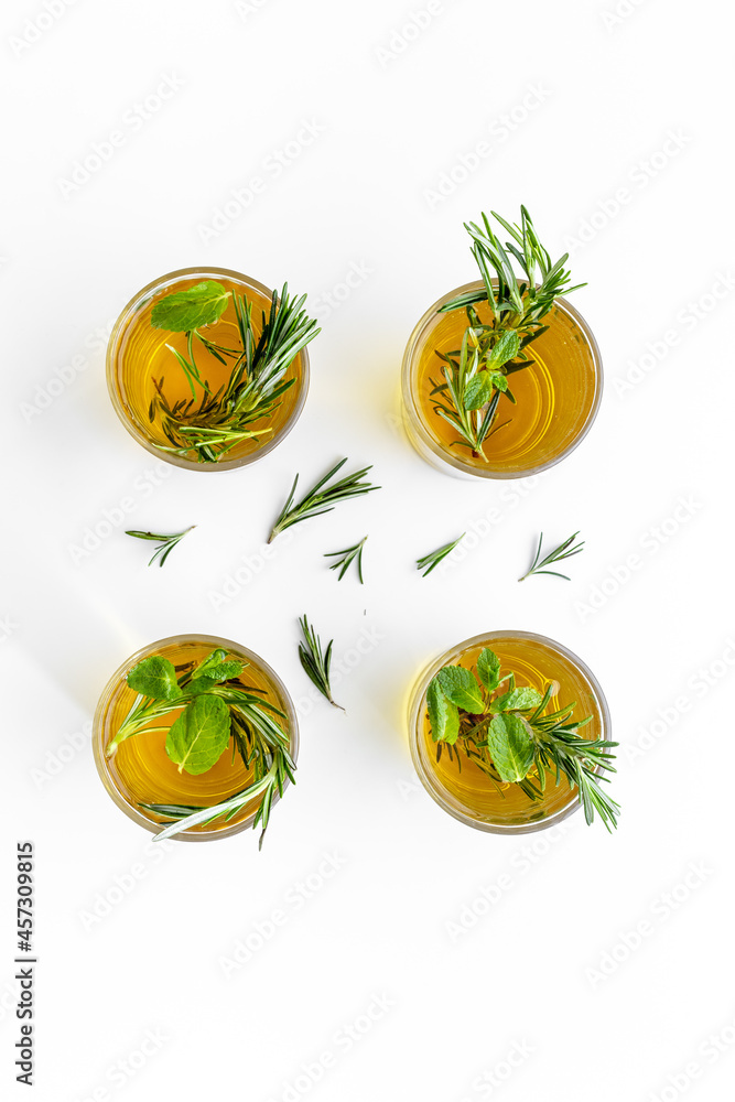 A lot of glasses of lemonade with cold tea and rosemary