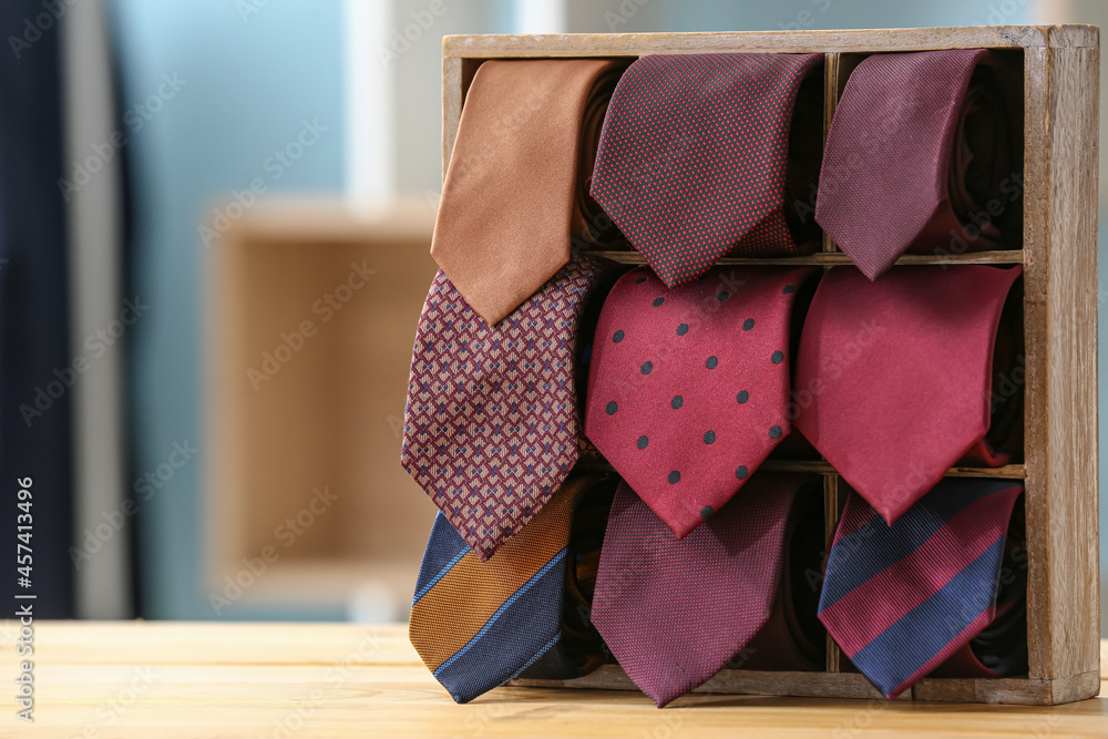 Box with stylish neckties on table