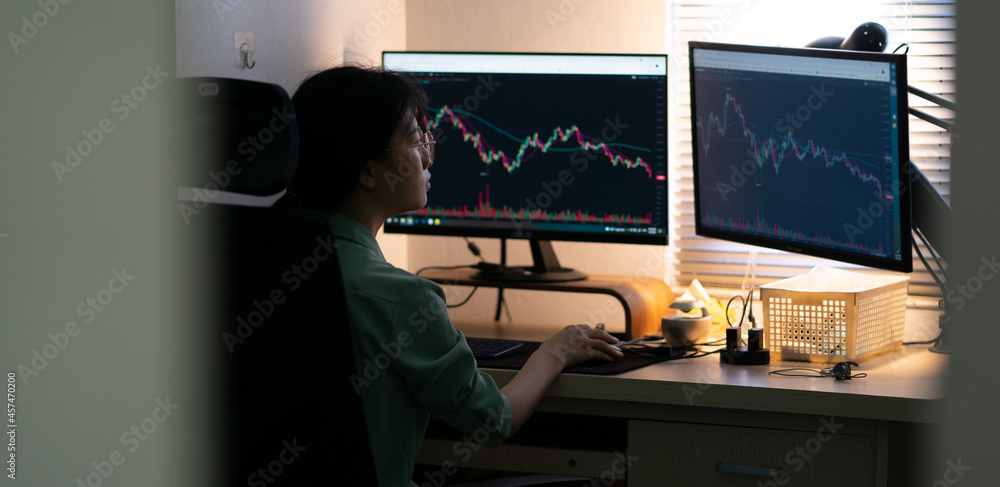 Asian businesswoman trading stock on computer