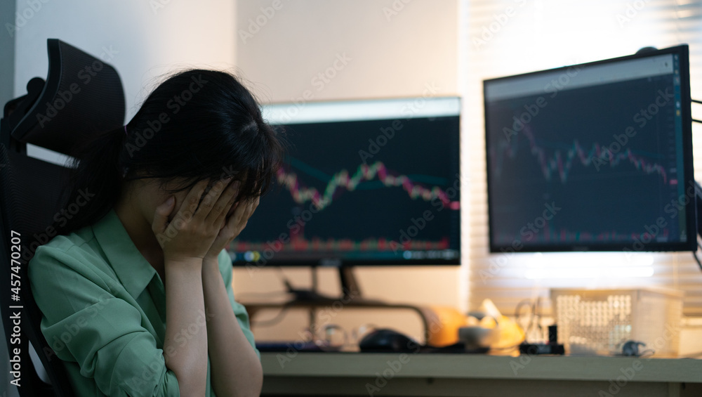 Asian businesswoman trading stock on computer