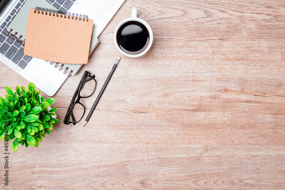 Work from home. desk office with laptop, blank notepad, coffee cup and pen on wood table. Flat lay t