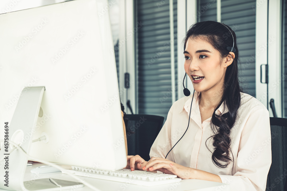 Businesswoman wearing headset working actively in office . Call center, telemarketing, customer supp