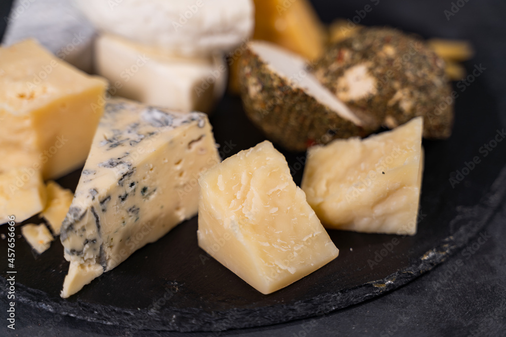 Cheese plate close up. Various types of flavored cheese. Wine appetizer.