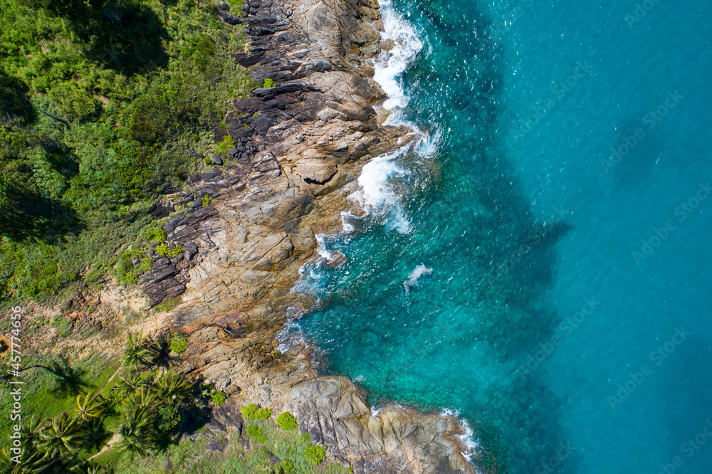 鸟瞰图自上而下，海浪拍打着海岸，阳光明媚，美丽的绿松石海面