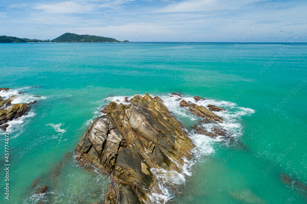 鸟瞰图自上而下，海浪拍打着海岸，阳光明媚，美丽的绿松石海面