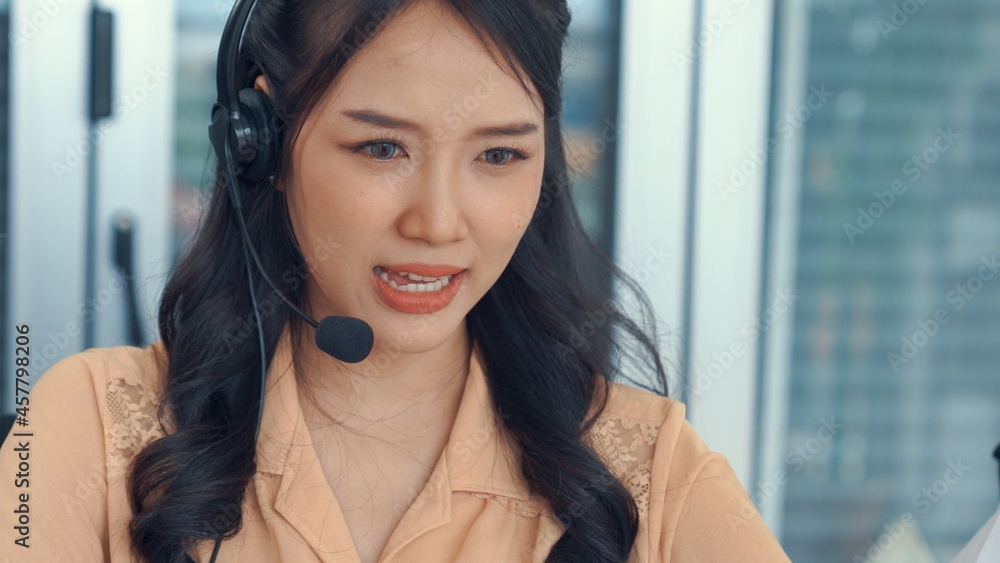 Businesswoman wearing headset working actively in office . Call center, telemarketing, customer supp