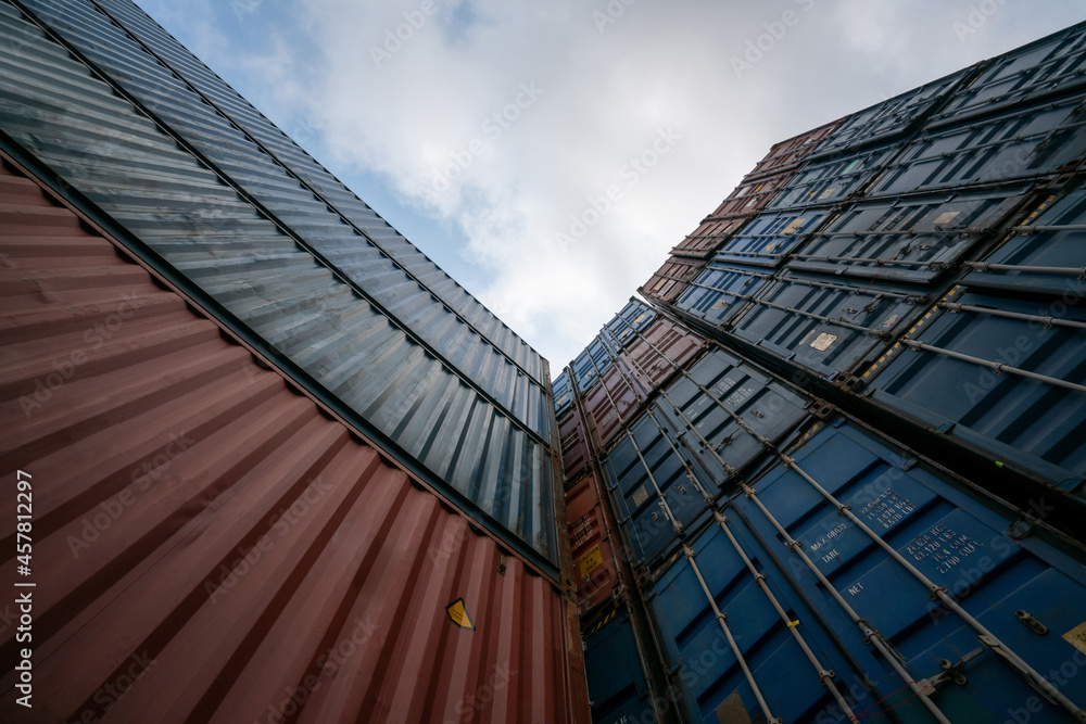 Cargo container for overseas shipping on high stack look up from ground . Logistics supply chain man