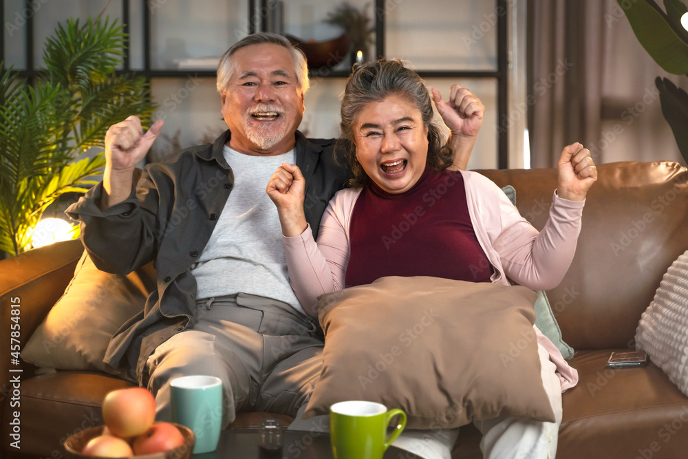 亚洲老夫妇在家看电视，亚洲老夫妇为体育比赛加油