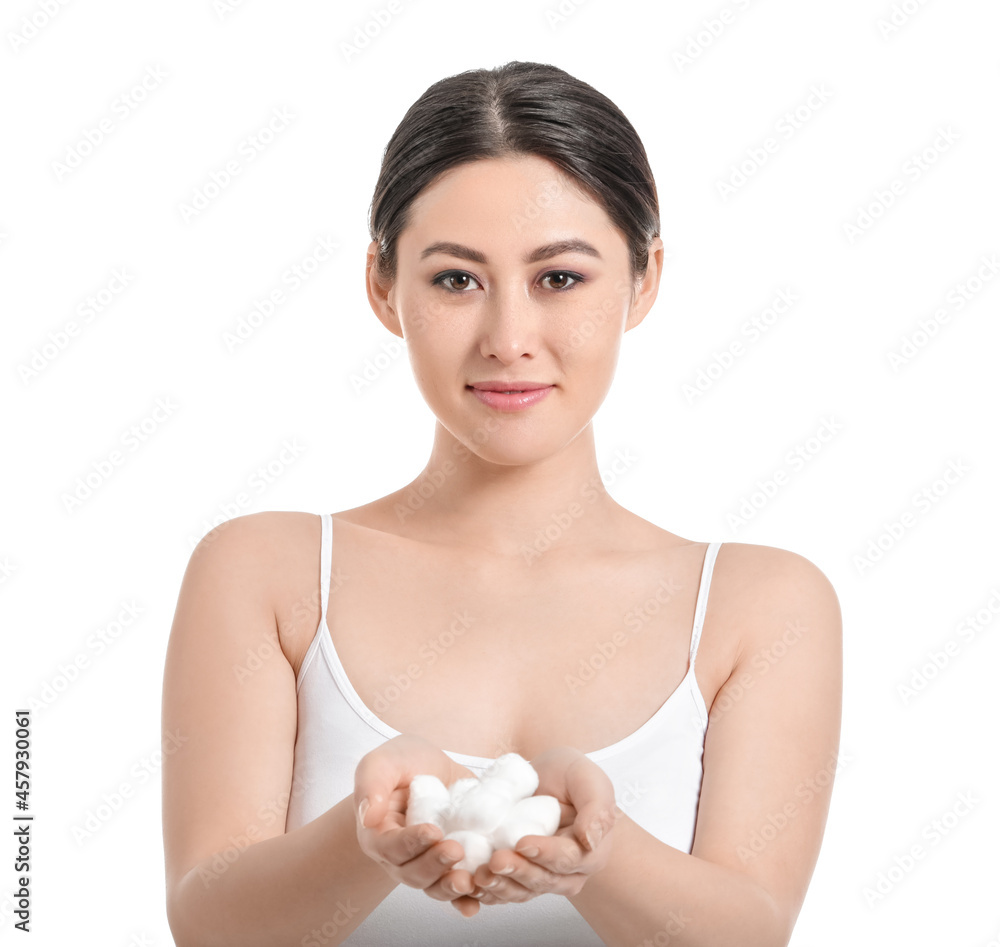 Beautiful young Asian woman with cotton wool on white background