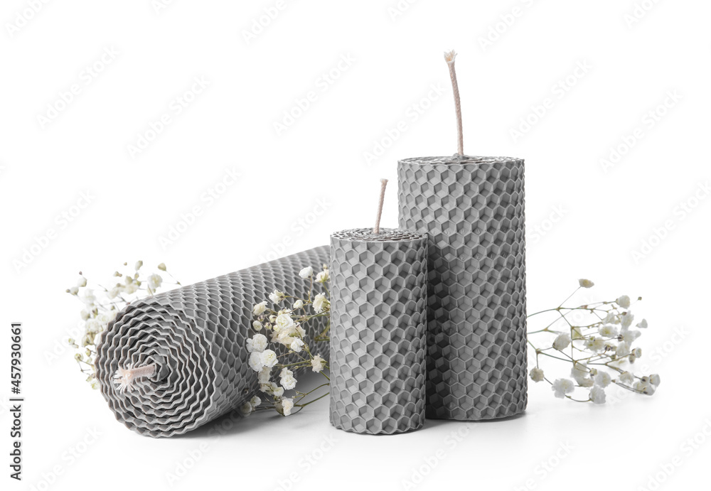 Wax candles and gypsophila flowers on white background