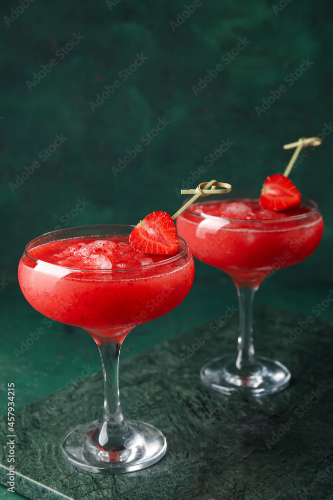 Glasses of tasty strawberry margarita on color background