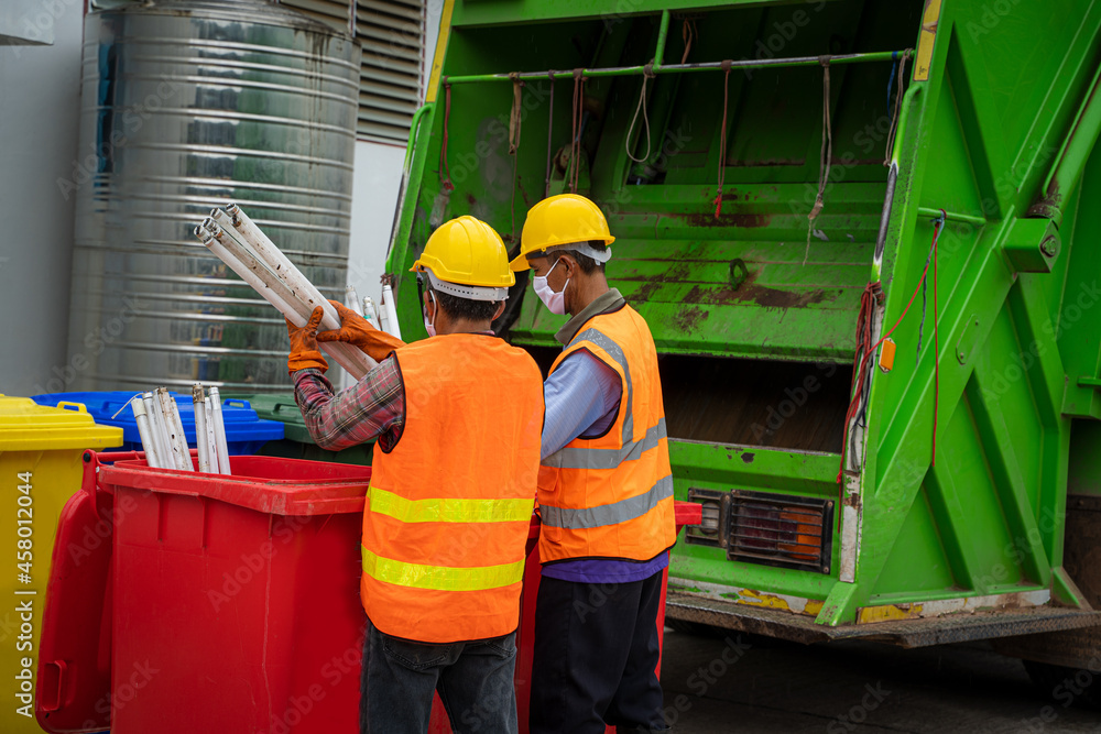 Worker of recycling garbage collector truck loading waste and trash bin,Waste collectors at work.