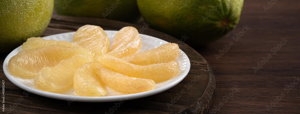 Fresh pomelo fruit on wooden table background.