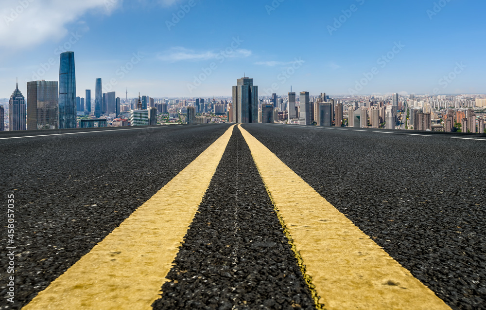 Panoramic skyline and empty asphalt road with modern buildings