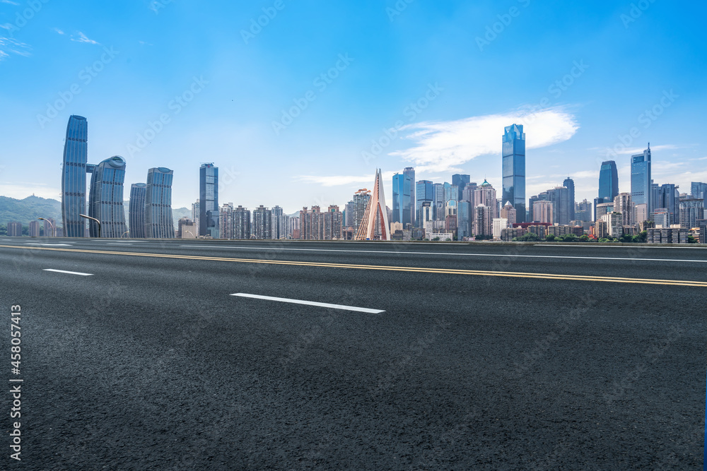 Panoramic skyline and empty asphalt road with modern buildings