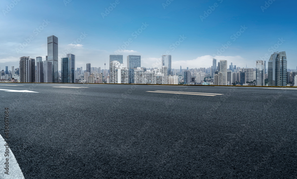 Panoramic skyline and empty asphalt road with modern buildings