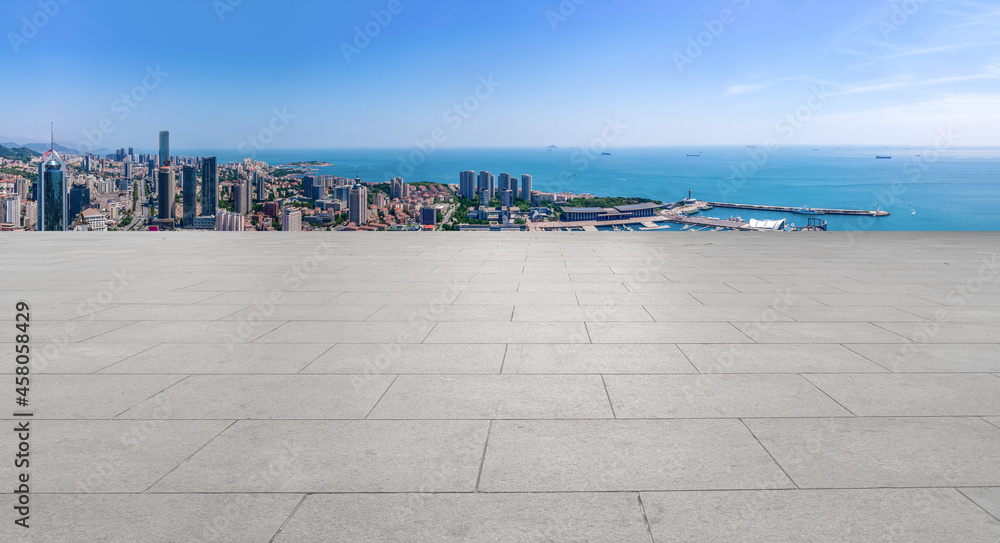 Panoramic skyline and empty square floor tiles with modern buildings