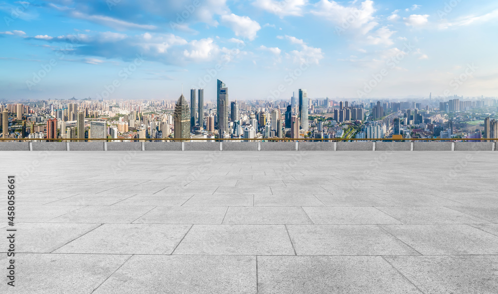 Panoramic skyline and empty square floor tiles with modern buildings