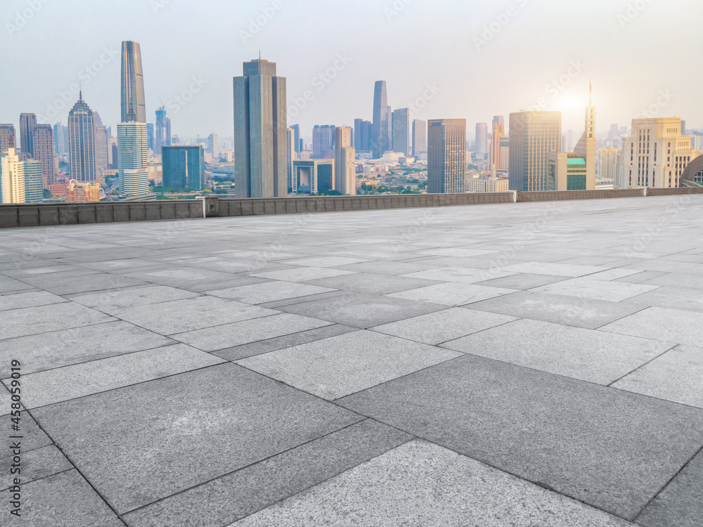 Panoramic skyline and empty square floor tiles with modern buildings