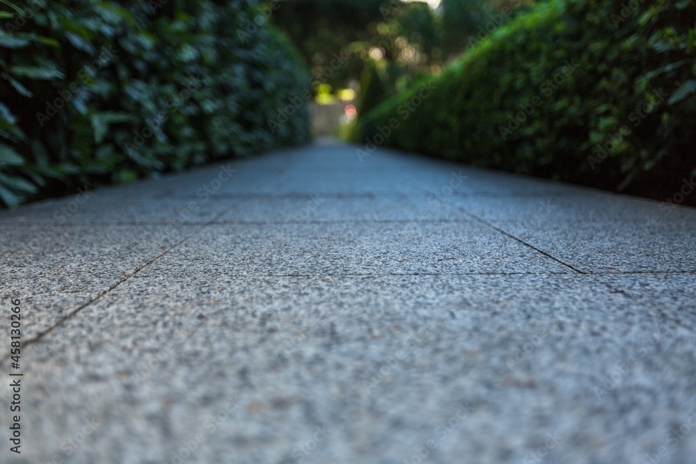 单色灰色砖石街道道路透视图。人行道，路面纹理背景