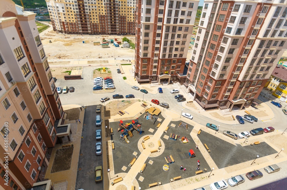 City courtyard or street with cars and playgrounds for children and walks.