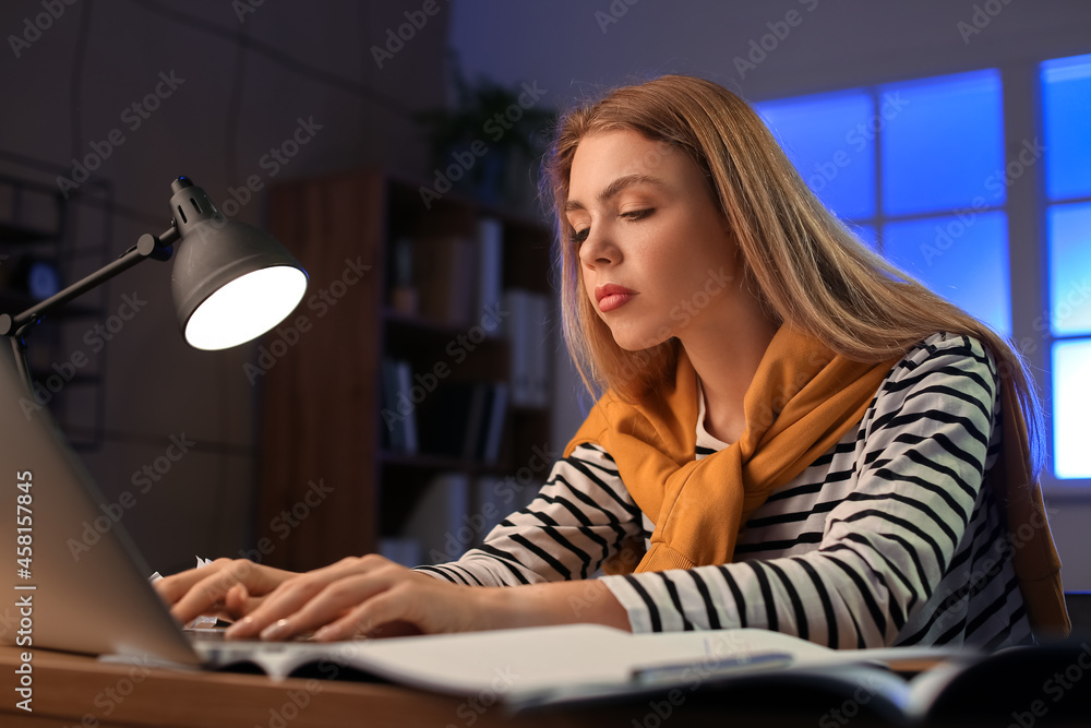 Female student preparing for exam at home late in evening