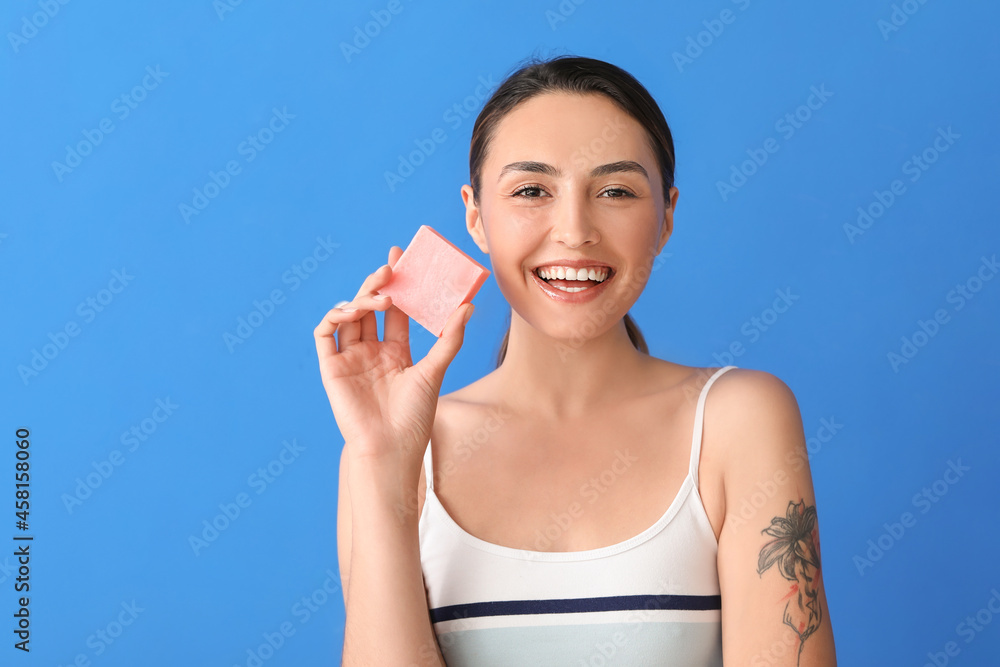 Beautiful young woman with soap on color background