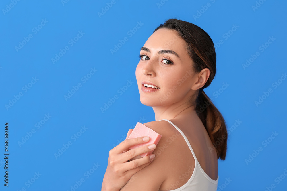 Beautiful young woman with soap on color background