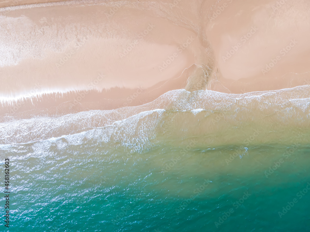 Aerial view of sandy beach and ocean with waves