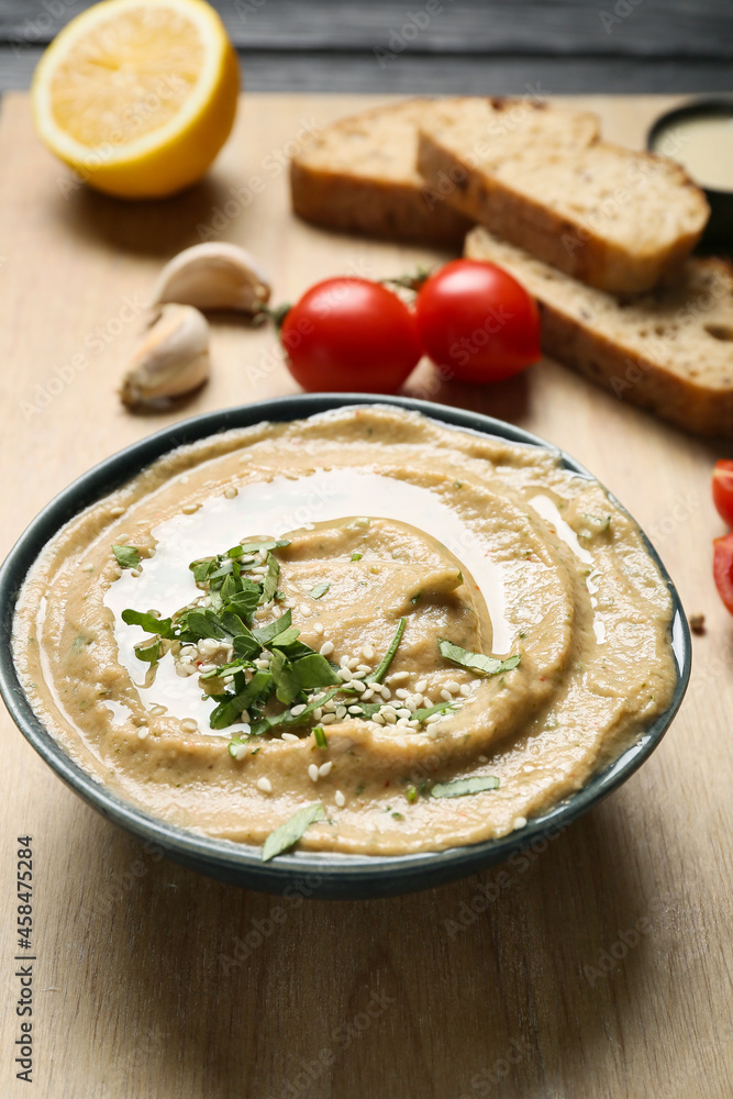 Bowl with traditional baba ghanoush on wooden table, closeup