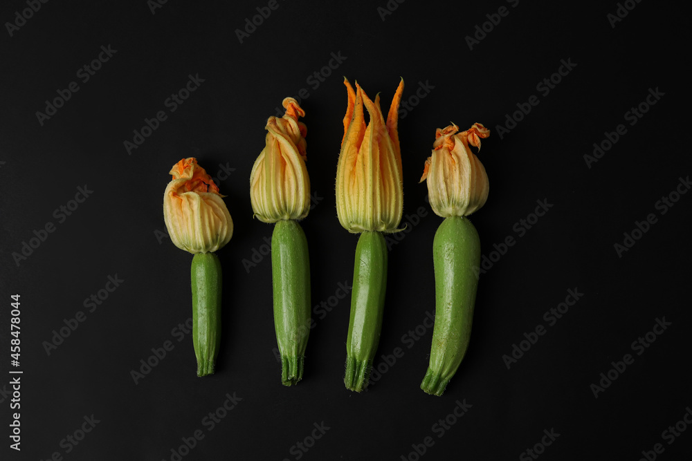 Fresh zucchini with flowers on dark background