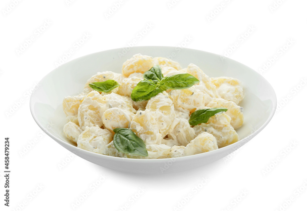 Bowl of delicious gnocchi with creamy sauce on white background