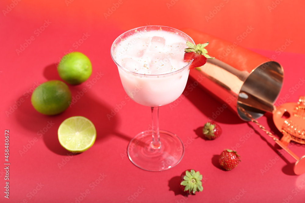 Composition with glass of strawberry Pina Colada cocktail, limes, berries and shaker on color backgr