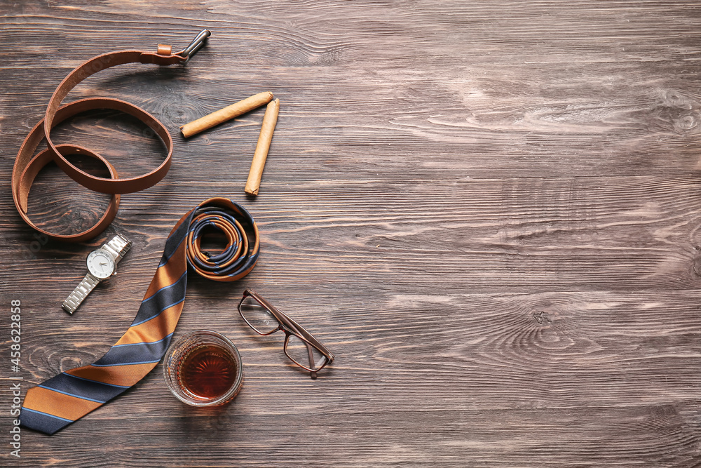 Stylish male accessories, glass of whiskey and cigars on wooden background