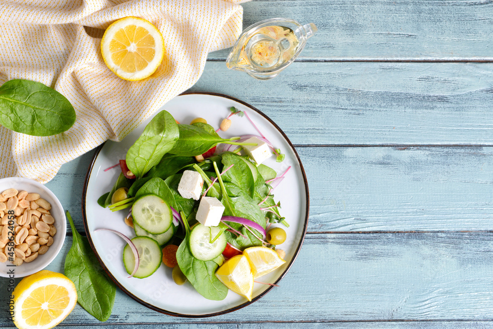 Plate with healthy salad on color wooden background