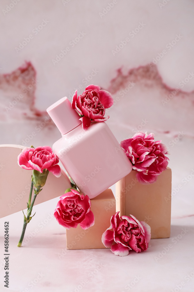 Composition with perfume bottle and carnation flowers on color background