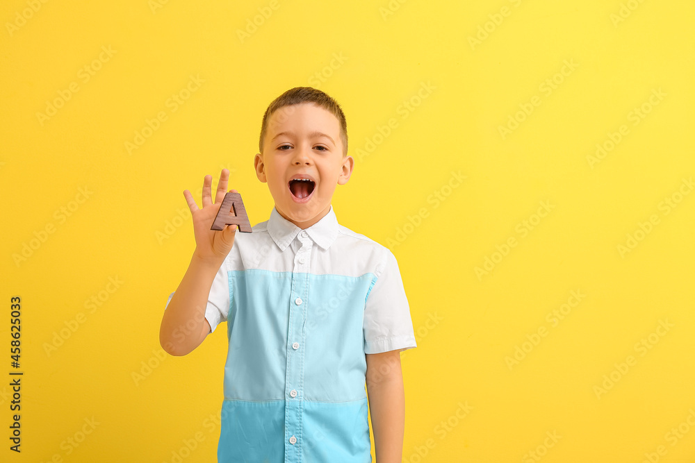 Little boy with letter A on color background