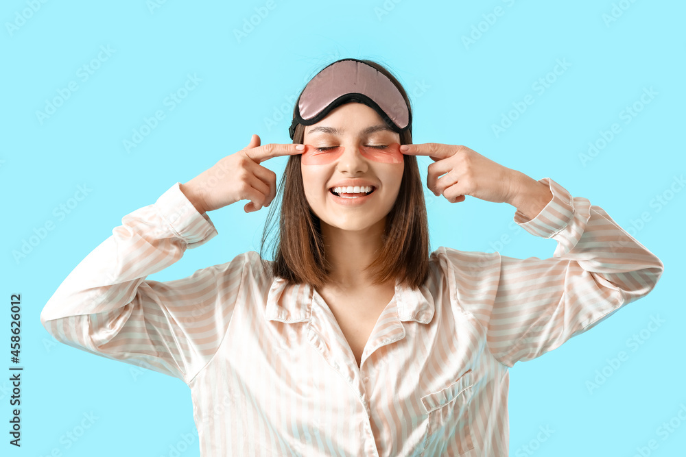 Young woman with under-eye patches on color background