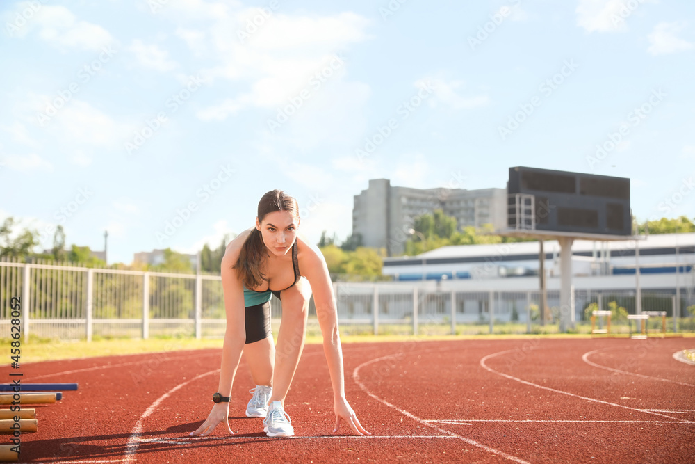 Sporty young woman running in the stadium