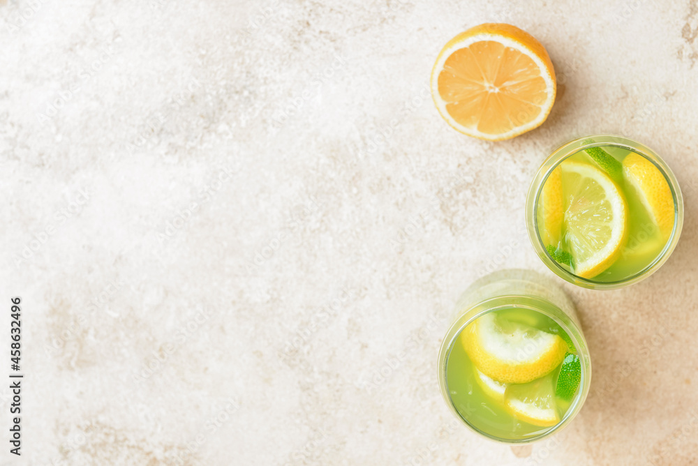 Glasses with tasty lemonade on light background