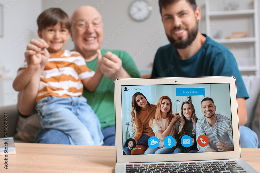 Happy man, his little son and father video chatting at home