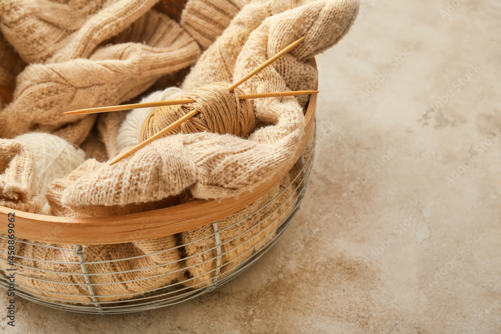 Basket with yarn and knitting needles on table, closeup