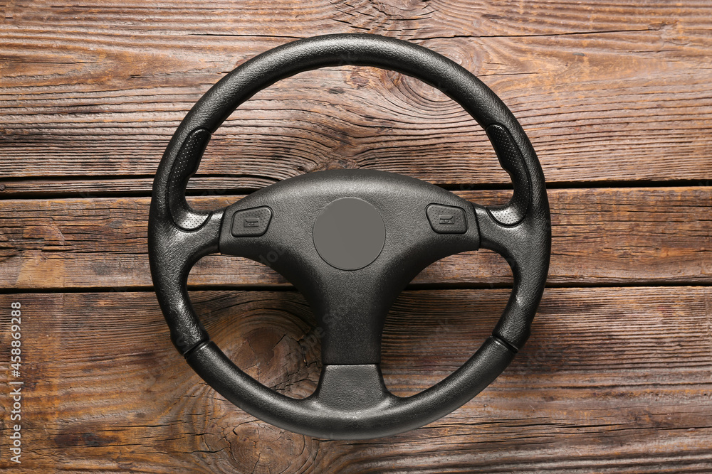 Modern steering wheel on wooden background