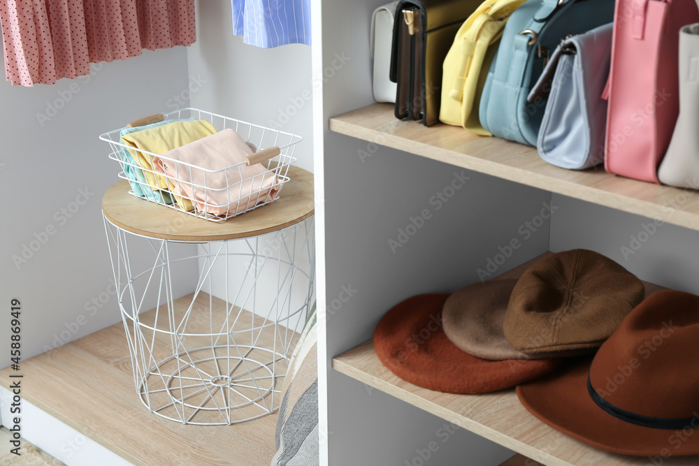 Wardrobe organizer with clothes on table in dressing room