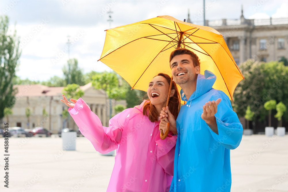 年轻夫妇带着雨伞在户外散步