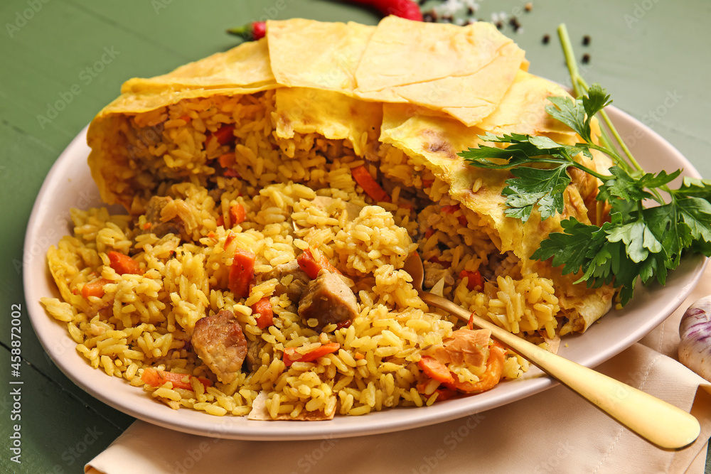 Plate with tasty Shah Pilaf on color wooden background, closeup