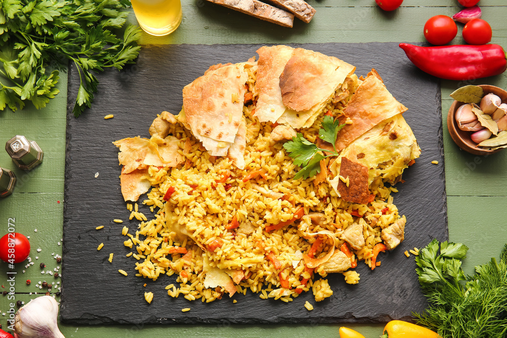 Board with tasty Shah Pilaf on color wooden background