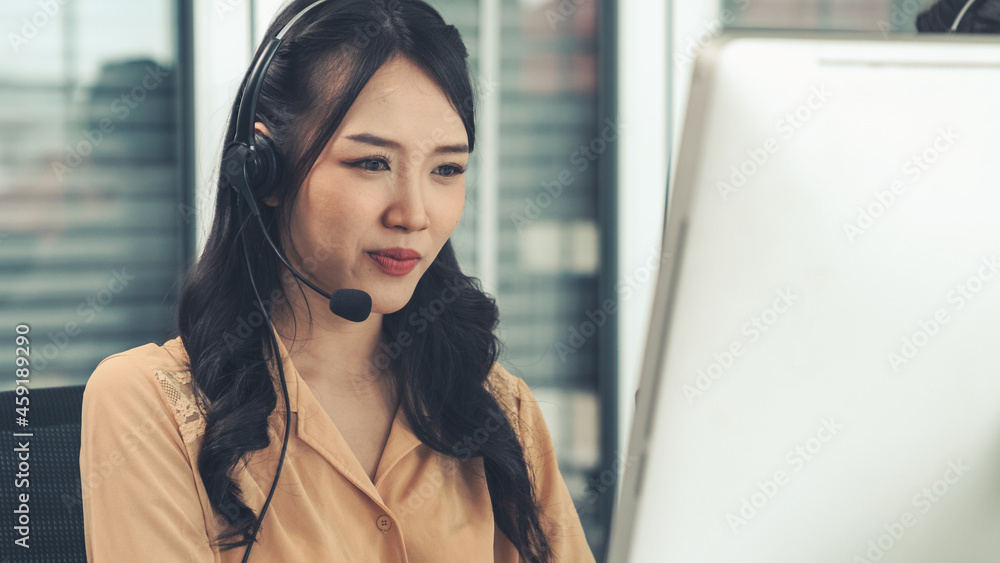 Businesswoman wearing headset working actively in office . Call center, telemarketing, customer supp