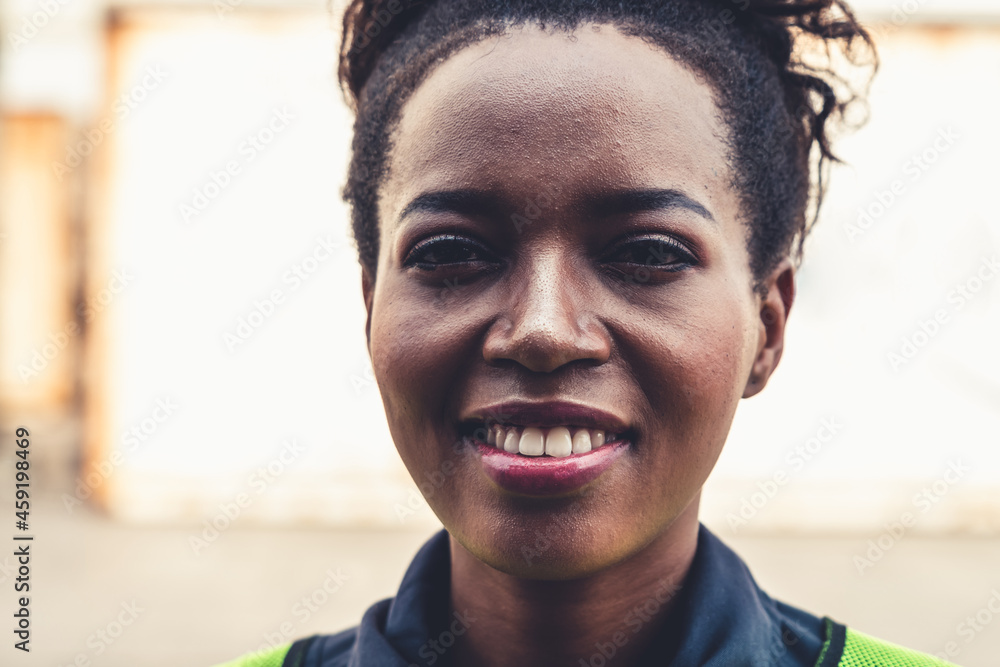 Young African American woman worker at overseas shipping container yard . Logistics supply chain man