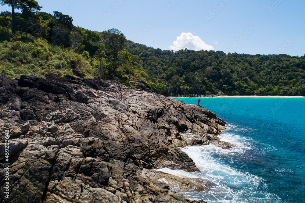 鸟瞰图自上而下，海浪拍打着海岸，阳光明媚，美丽的绿松石海面